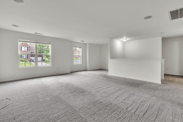 empty room featuring light carpet and baseboards