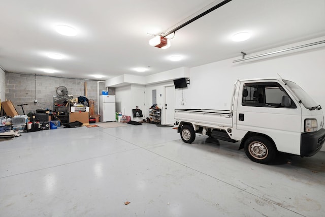 garage with freestanding refrigerator and a garage door opener