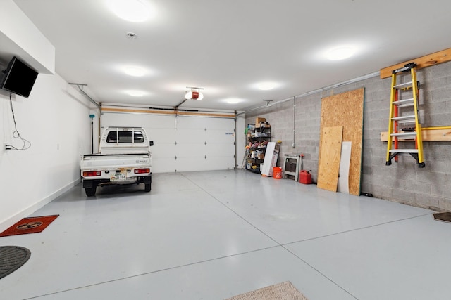 garage with concrete block wall and a garage door opener
