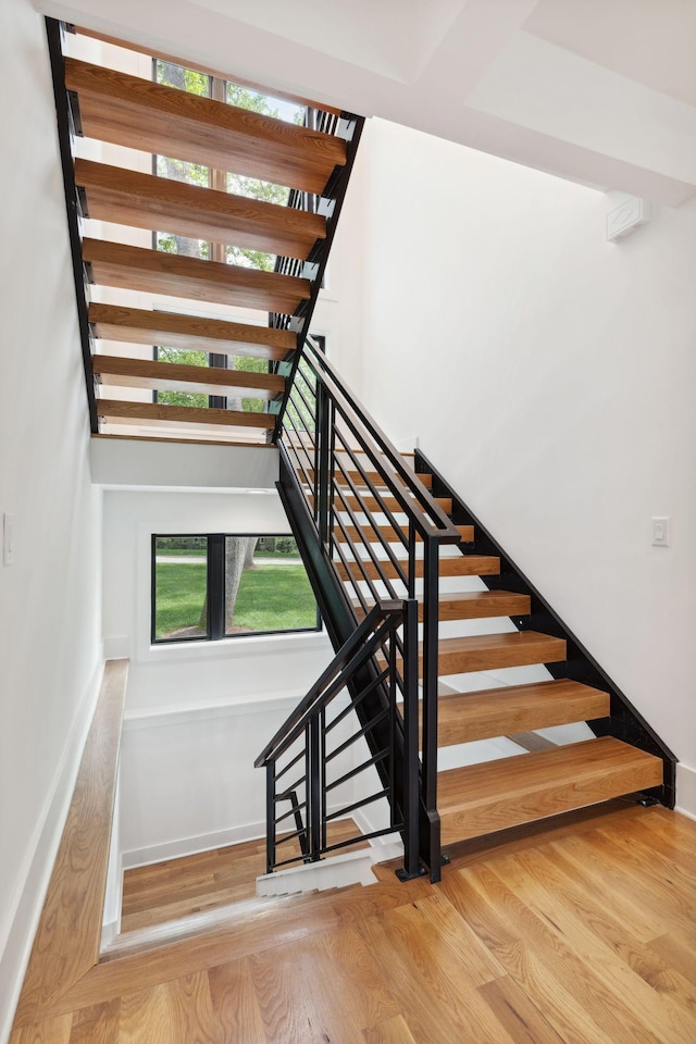 staircase with baseboards and wood finished floors