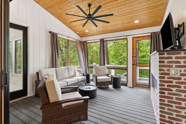 sunroom with wood ceiling, a ceiling fan, vaulted ceiling, plenty of natural light, and an outdoor hangout area