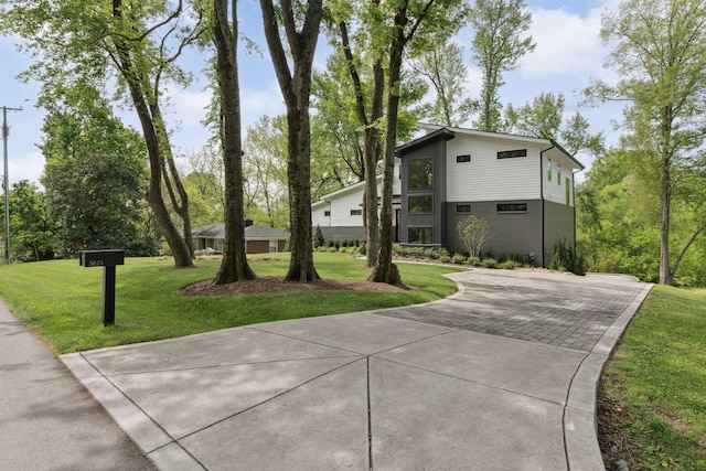 view of front of home featuring driveway and a front lawn
