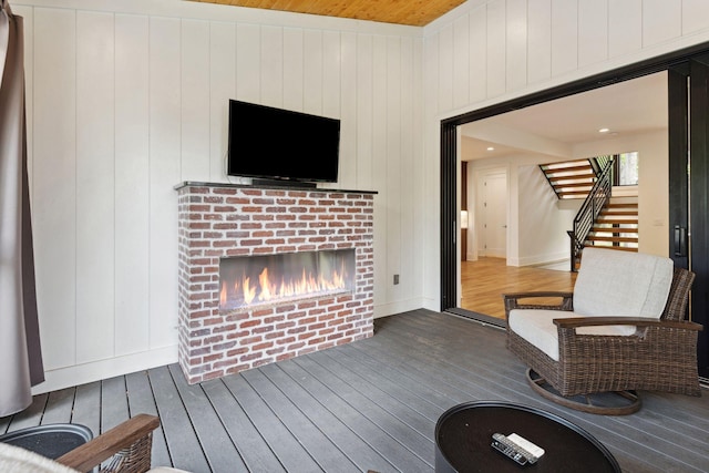 wooden terrace featuring a brick fireplace