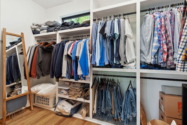 walk in closet with wood finished floors