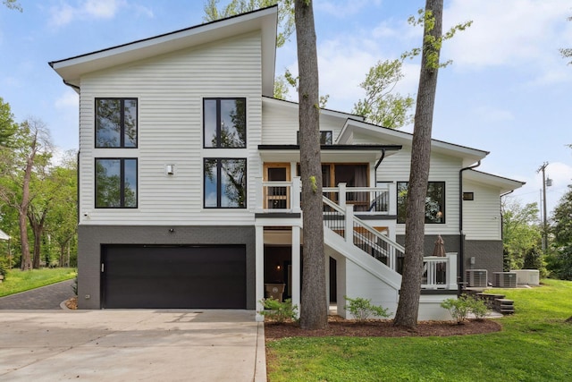 view of front of property featuring concrete driveway, an attached garage, brick siding, a front yard, and cooling unit