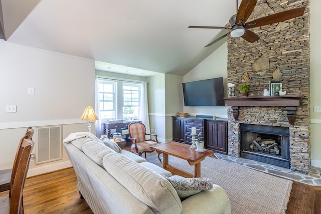 living area with wood finished floors, a ceiling fan, a fireplace, baseboards, and high vaulted ceiling