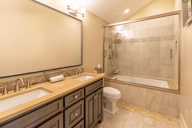 bathroom with tiled shower / bath, vaulted ceiling, toilet, double vanity, and tile patterned floors