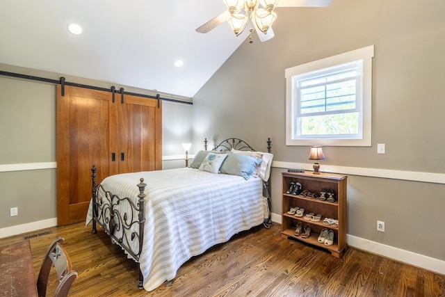 bedroom featuring lofted ceiling, wood finished floors, baseboards, a barn door, and a ceiling fan