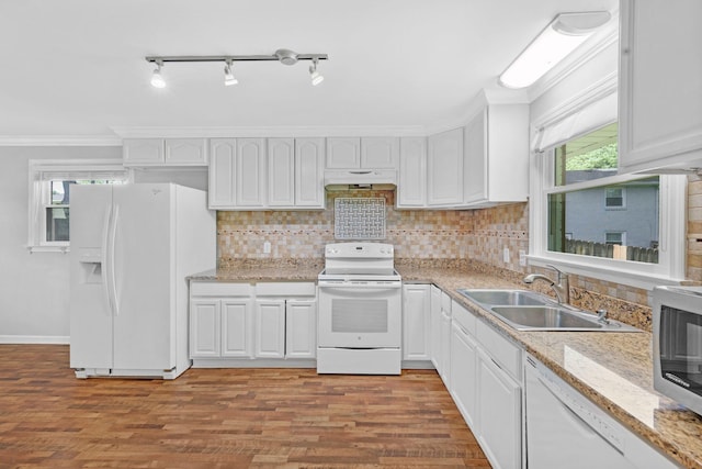kitchen featuring white appliances, under cabinet range hood, a sink, white cabinets, and light wood-type flooring