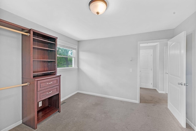 unfurnished bedroom with carpet flooring and baseboards
