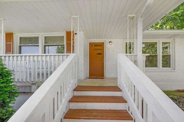 entrance to property with brick siding and covered porch