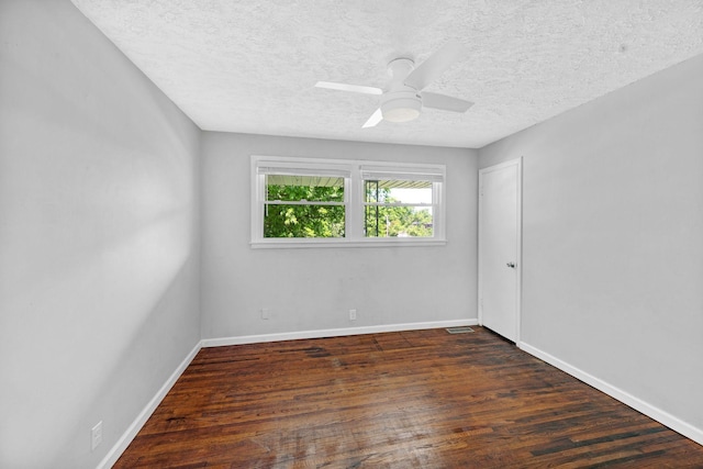 spare room with wood finished floors, a textured ceiling, baseboards, and ceiling fan