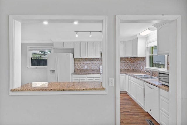 kitchen with white appliances, a sink, white cabinetry, and ornamental molding