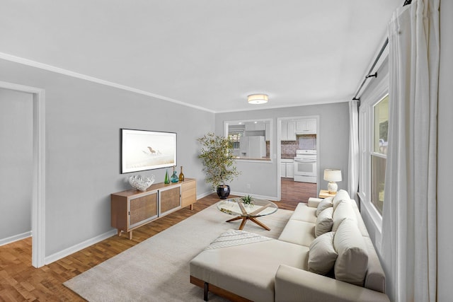 living room with wood finished floors, baseboards, and ornamental molding