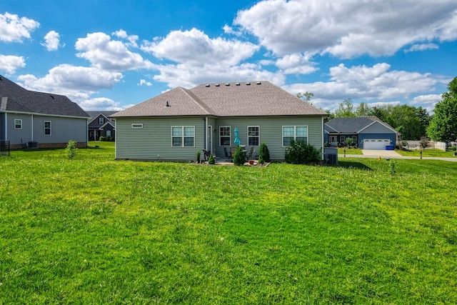 rear view of house featuring a lawn and a garage