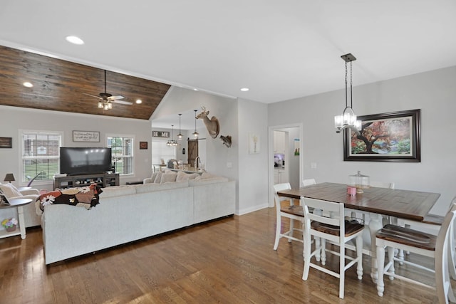 dining space featuring a ceiling fan, vaulted ceiling, dark wood-style flooring, a chandelier, and recessed lighting