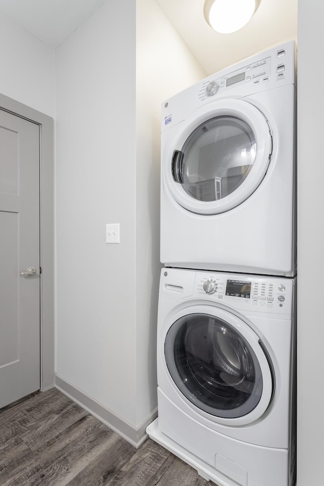782 Riverfront Pkwy Unit 216, Chattanooga, TN 37402 - clothes washing area featuring stacked washer / dryer, wood finished floors, and baseboards