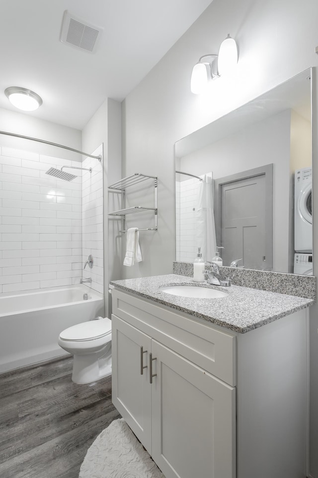 782 Riverfront Pkwy Unit 216, Chattanooga, TN 37402 - full bathroom with wood finished floors, toilet, shower / tub combo with curtain, stacked washer / drying machine, and vanity