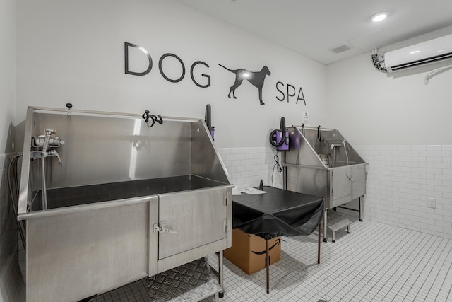 782 Riverfront Pkwy Unit 216, Chattanooga, TN 37402 - miscellaneous room featuring pet washing station, an AC wall unit, and tile patterned flooring