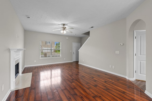 5029 Luker Ln, Antioch, TN 37013 - unfurnished living room featuring a ceiling fan, dark wood-type flooring, arched walkways, a high end fireplace, and baseboards