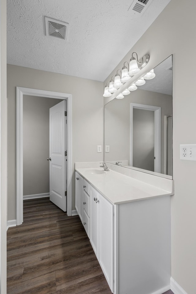 5029 Luker Ln, Antioch, TN 37013 - bathroom with wood finished floors, vanity, a textured ceiling, and baseboards