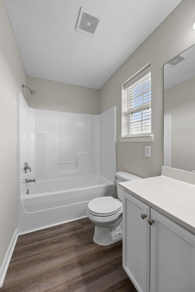 5029 Luker Ln, Antioch, TN 37013 - bathroom featuring toilet, wood finished floors,  shower combination, a textured ceiling, and vanity