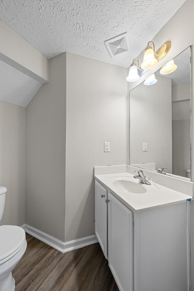 5029 Luker Ln, Antioch, TN 37013 - bathroom featuring toilet, wood finished floors, vanity, baseboards, and a textured ceiling