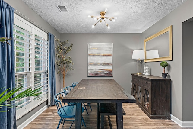 102 Braxton Park Ct, Goodlettsville, TN 37072 - dining space with a chandelier, wood finished floors, a textured ceiling, and baseboards