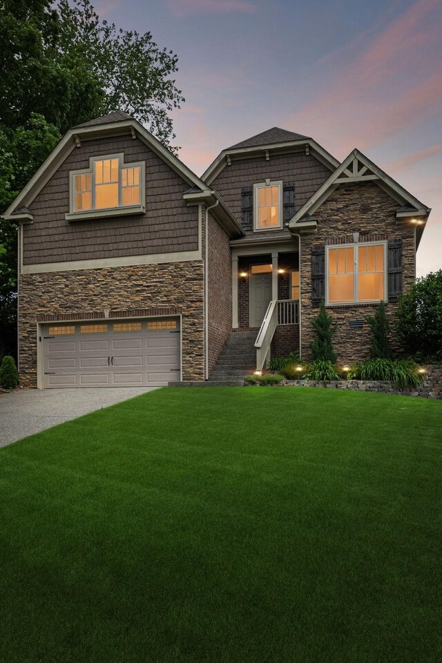 craftsman-style house featuring stone siding, an attached garage, a lawn, and concrete driveway