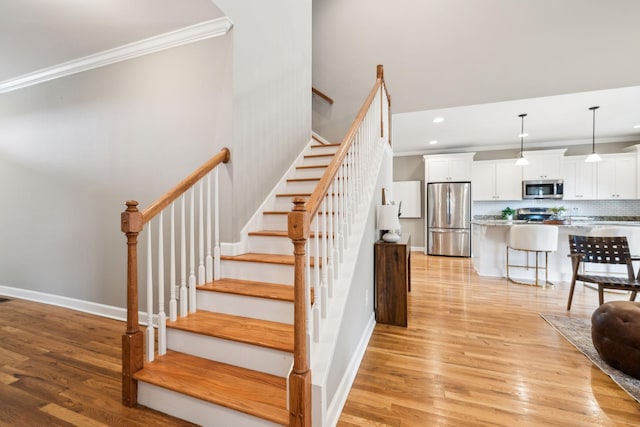stairs featuring crown molding, baseboards, recessed lighting, and wood finished floors