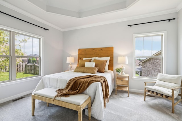 bedroom with light colored carpet, baseboards, ornamental molding, and a raised ceiling