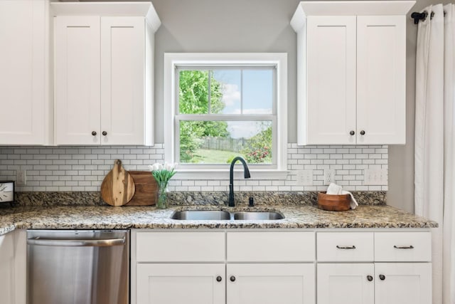 kitchen with dishwasher, a sink, decorative backsplash, and white cabinetry