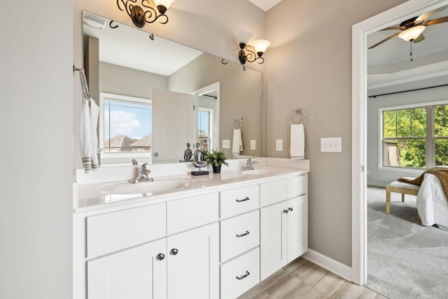full bath with double vanity, ceiling fan, and baseboards