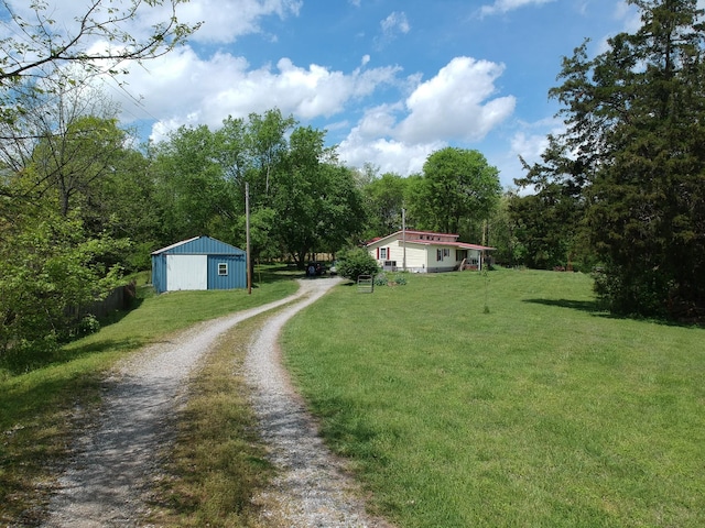 170 School House Ln, Castalian Springs, TN 37031 - view of front of house with dirt driveway, a front yard, an outbuilding, and a garage