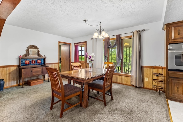 170 School House Ln, Castalian Springs, TN 37031 - dining space with wainscoting, a textured ceiling, wooden walls, a chandelier, and light carpet