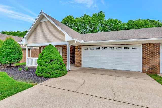 ranch-style house featuring brick siding, concrete driveway, an attached garage, and covered porch