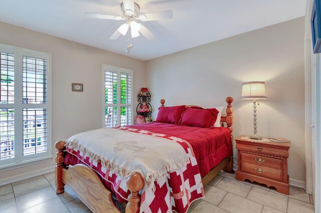 bedroom with light tile patterned flooring, baseboards, and a ceiling fan