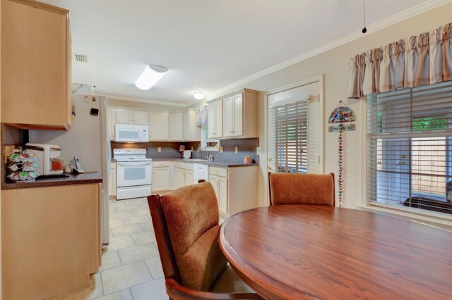 kitchen with white appliances, crown molding, and light tile patterned floors