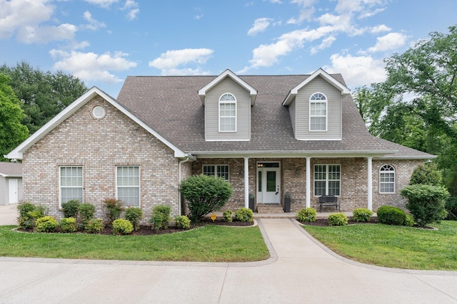 673 Newton Ln, Gallatin, TN 37066 - view of front of house with a porch, a front yard, brick siding, and a shingled roof