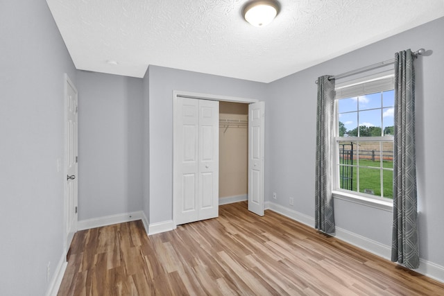 203 Abbigael Dr, Portland, TN 37148 - unfurnished bedroom with light wood-style floors, a textured ceiling, baseboards, and a closet