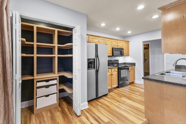 203 Abbigael Dr, Portland, TN 37148 - kitchen featuring black appliances, a sink, light wood finished floors, light brown cabinetry, and dark countertops