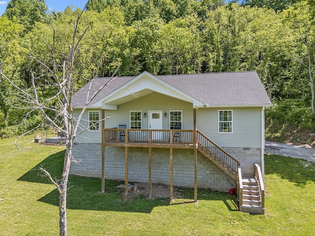rear view of property featuring roof with shingles, stairs, a yard, and a wooden deck