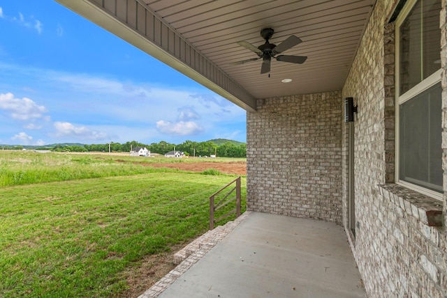 view of patio / terrace with a ceiling fan and a view of countryside