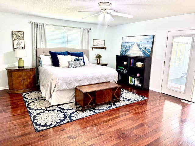 bedroom featuring wood finished floors, a ceiling fan, a textured ceiling, and baseboards