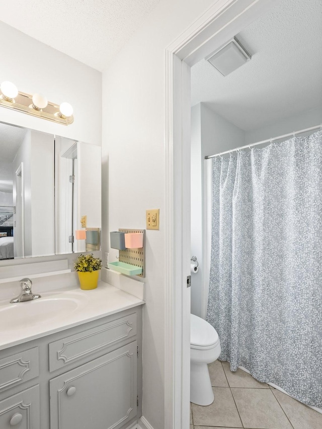 full bathroom with tile patterned flooring, vanity, toilet, a textured ceiling, and curtained shower
