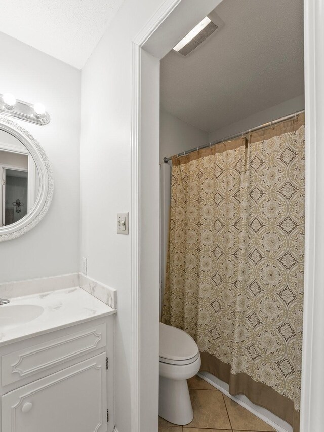 bathroom with tile patterned flooring, toilet, vanity, and a shower with curtain