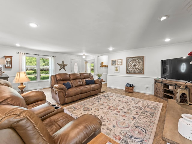 living room featuring crown molding, wood finished floors, recessed lighting, and wainscoting