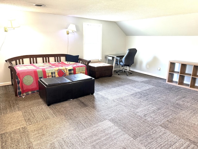 carpeted bedroom featuring lofted ceiling, baseboards, and a textured ceiling