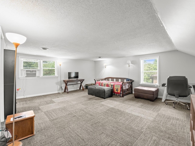 carpeted living room with a desk, a textured ceiling, healthy amount of natural light, lofted ceiling, and baseboards
