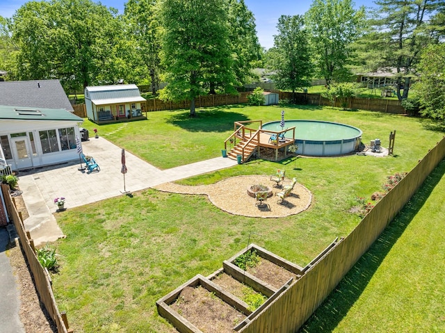 view of yard with an outdoor structure, a patio, a vegetable garden, and a storage unit